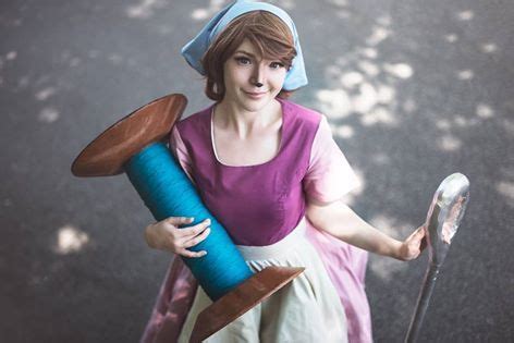 A Woman Dressed In Costume Holding A Blue Object