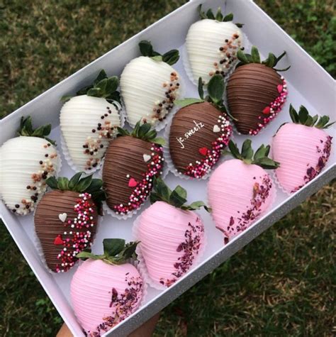 A Box Filled With Chocolate Covered Strawberries On Top Of Grass