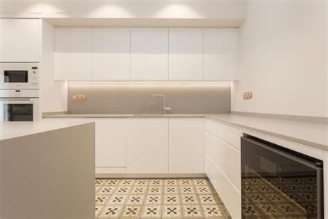 El acabado brillante de las superficies de trabajo, de silestone blanco, reflejan más la luz. Cocina Blanca y Gris en Ciutat Vella | OMO Barcelona