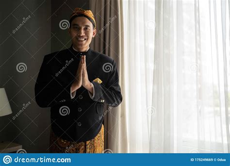 Asian Man Wearing Traditional Clothes Of Indonesian Beskap With Welcome