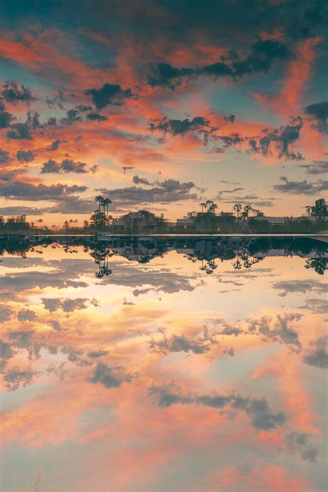 The Sky Is Reflecting In The Water And Clouds Are Reflected On The