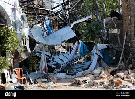 A woman carries her belongings as she leaves her destroyed house in