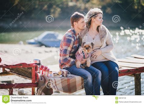 Young Future Parents And Their Dog In A Funny Costume Sitting On A