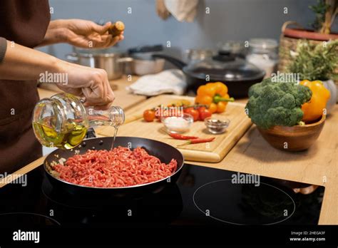 Hands Of Woman Pouring Olive Oil Into Frying Pan With Raw Minced Meat