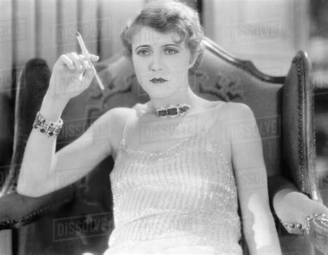 Elegant Woman In An Evening Dress And Jewelry Smoking A Cigarette