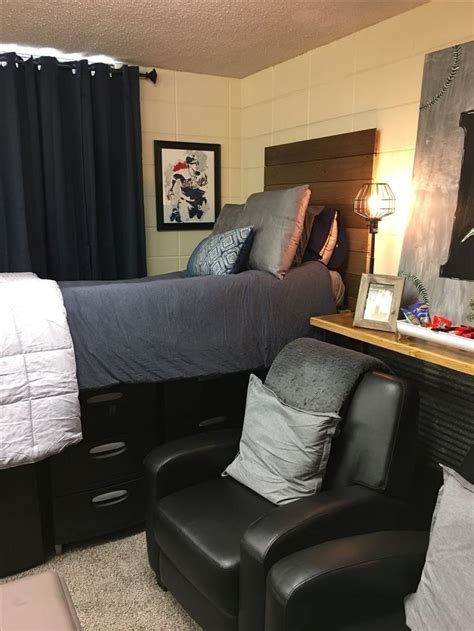 A Bedroom With Two Chairs And A Bed In The Corner Next To A Night Stand