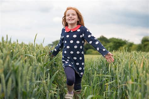 A Little Girl With Red Hair Running Through A Wheat Field By Stocksy