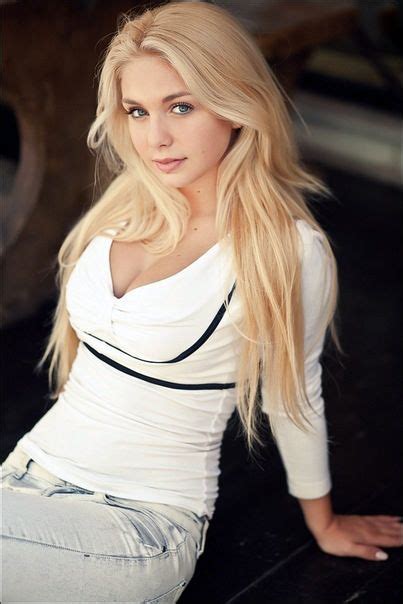 A Woman With Long Blonde Hair Sitting On The Ground