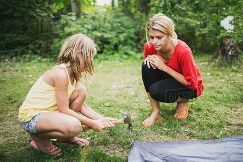 A Mother Watches Her Daughter Hammer In A Tent Peg Peachland British Columbia Canada Stock