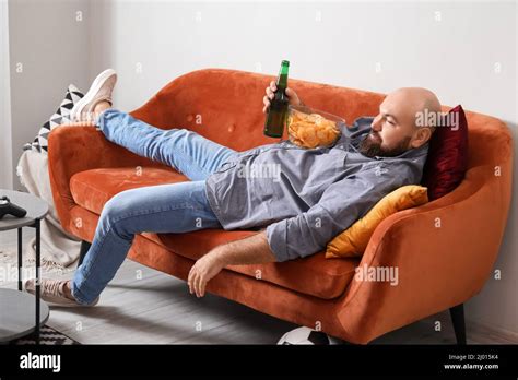 Funny Lazy Man Drinking Beer And Eating Chips While Watching TV At Home