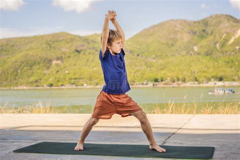 Boy Doing Yoga On A Yoga Mat Against A Background Of Mountains Stock