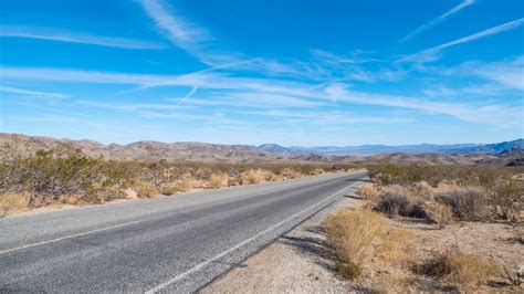 Road Between Hills Bushes Dry Grasses Under Blue Sky During Daytime 4k