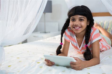 Smiling Girl Using Digital Tablet On Bed At Home Stock Image Image Of