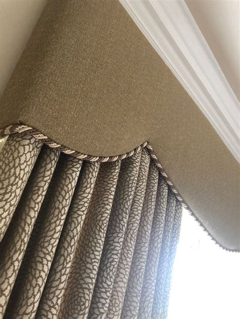 A Close Up View Of A Window Curtain With Pleated Drapes On The Side