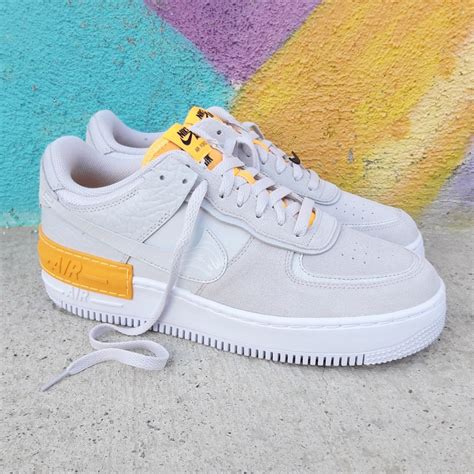 Dressed in a white, particle grey, grey fog, and photon dust color scheme. Nike Air Force 1 Shadow Vast Grey Laser Orange CU3446-001