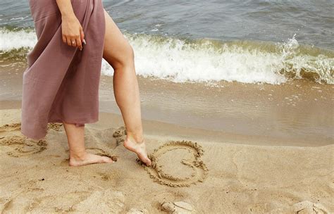 Woman Draws With Her Foot Heart On The Sand By Sea Photograph By
