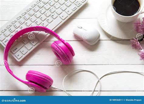 Headphones And Coffee Cup On Wooden Desk Table With Pink Flower Music