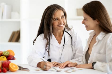 premium photo happy european middle aged lady doctor nutritionist in white coat advises woman
