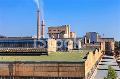 Large Factory With Smoking Chimneys Against The Blue Sky