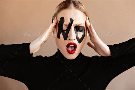 Woman With Written Word No On Her Face Poses Anxiously With Her Mouth