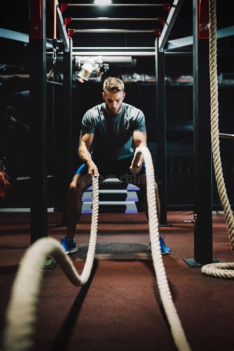Fit Man Working Out With Battle Ropes At Fitness Gym Stock Image