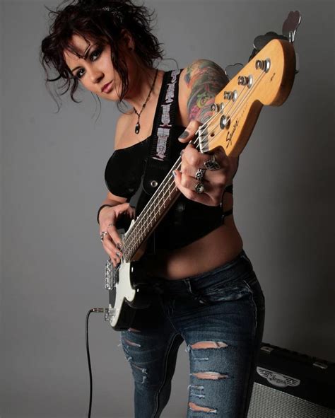 a woman holding a bass guitar in her right hand