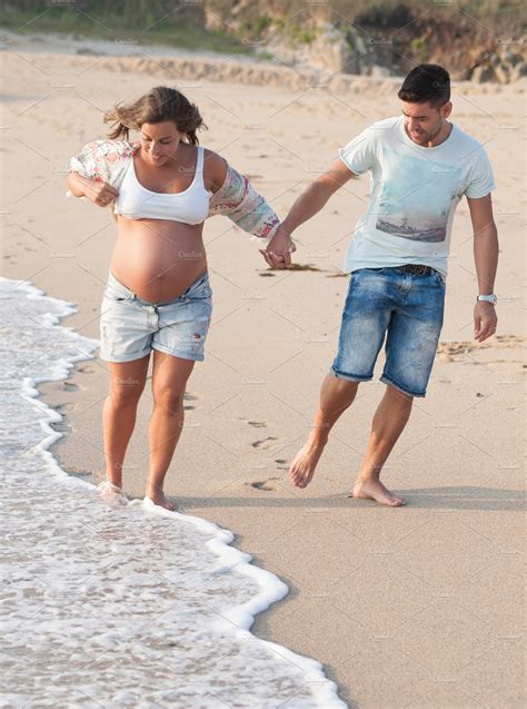 Happy Pregnant Couple On Beach High Quality People Images ~ Creative Market
