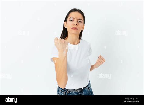 Portrait Of Serious Angry Young Woman Holding Fist In Threatening Pose