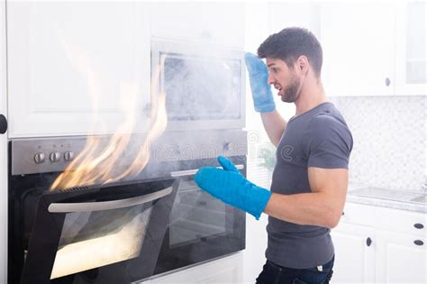 Man Looking At Fire Coming From Microwave Oven Stock Image Image Of