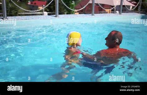 Grandpa Teaches Granddaughter To Swim In Swimming Pool Stock Video