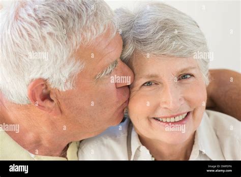 Senior Woman Getting A Kiss On The Cheek From Partner Stock Photo Alamy