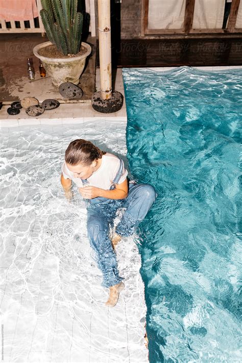 Young Woman Wearing All Her Clothes While Swimming In Pool During Night
