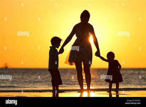 Siluetas De Una Madre Y Sus Dos Hijos En La Playa En El