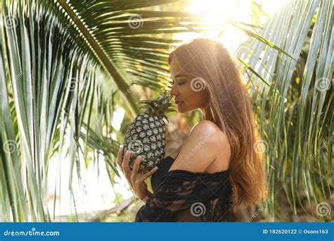 Girl Holds Pineapple In Hands On The Background Of The Pool In The Tropics Stock Photo Image