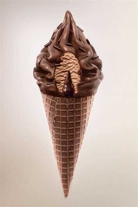 An Ice Cream Cone With Chocolate Icing And Pine Cones In It S Center