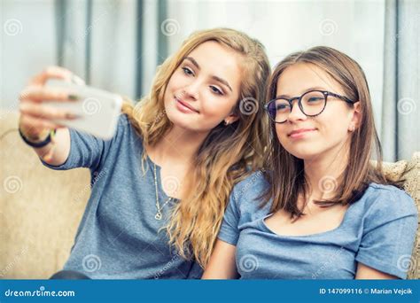 Girls Smile And Take A Selfie Together Grimaces Wink And Sign Four