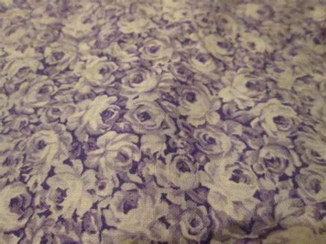 A Close Up View Of A Purple And White Flowered Bedspread On A Bed
