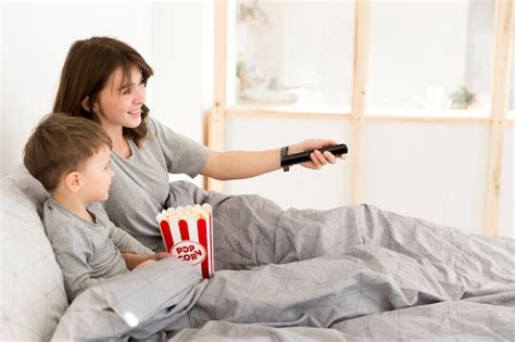 Madre E Hijo En La Cama Viendo Tv Foto Gratis