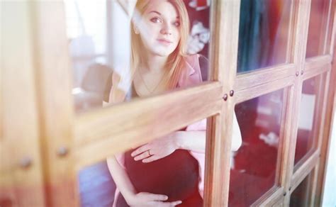 linda jovem grávida no nono mês dentro de casa foto premium