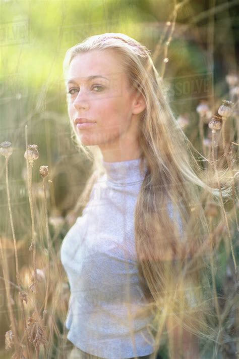 Portrait Confident Beautiful Blonde Teenage Girl In Tall Grass Stock