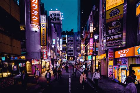 Busy Street In Japan At Night With Street Signs And Shop