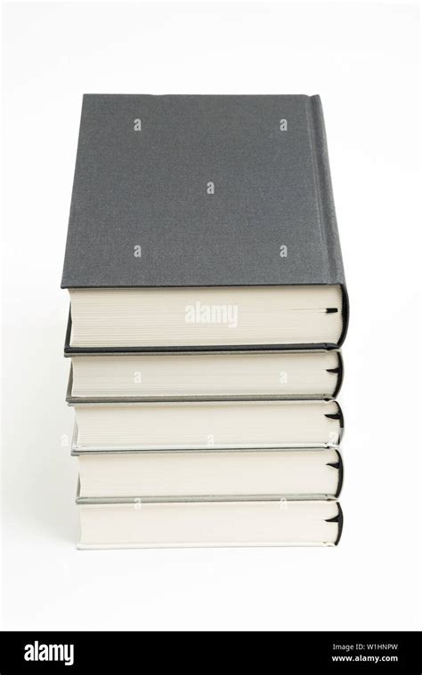 A Set Of Five Neatly Stacked And Arranged Monochromatic Cloth Bound Books On A Plain White