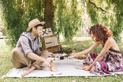 Happy Couple Having A Picnic In A Park Stock Photo