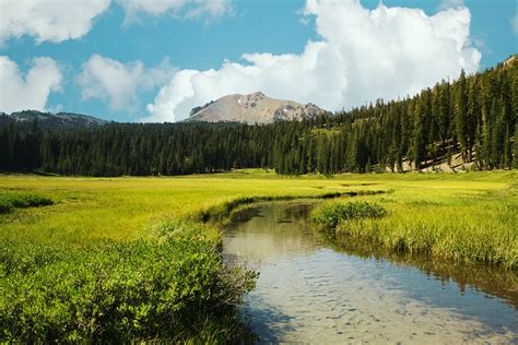 Brook In Meadow Near Mountain Valley In Sunlight · Free Stock Photo