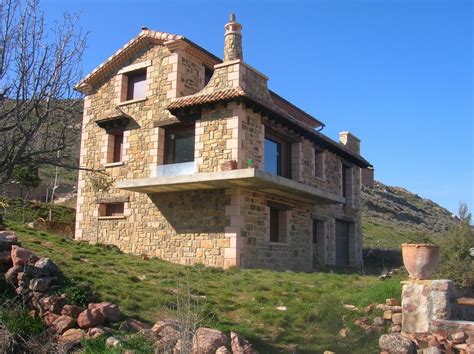 Casa de campo tipo pueblo con revestimiento exterior de ladrillo visto y aberturas de aluminio y hierro negro. 6 motivos para comprar una casa de piedra en Galicia ...