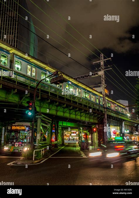 A Yamanote Line Passenger Train On Elevated Railway Above Busy Streets
