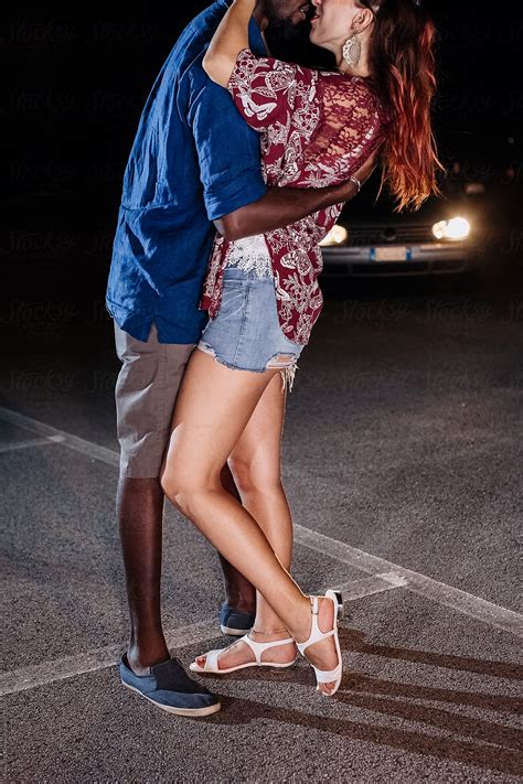 black man and a white woman kissing on the street by stocksy contributor mauro grigollo
