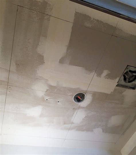 Applying tile with adhesives 5. 7 Easy Steps for Installing Faux Tin Ceiling Tiles