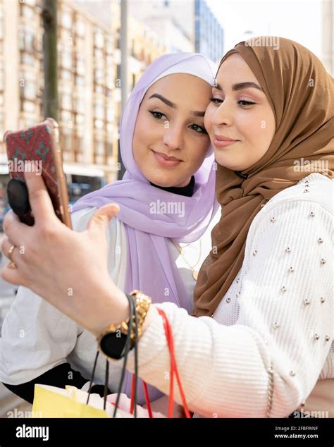 Arab Female Friends Taking Selfie Through Smart Phone While Shopping