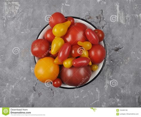 Variety Of Tomato Cultivars In Enamel Bowl On Concrete Stock Photo